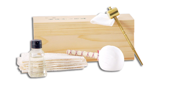 Aka 1003-GT, the kit contains blade oil (traditional choji oil), rice papers, an oiling cloth, a powder ball for blade polishing, a brass awl and hammer, and saya shimming veneer. The kit is contained in a fitted wooden box.
